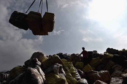 资料图：工作人员在深圳土洋码头搬运走私废旧衣物。新华社记者 毛思倩 摄