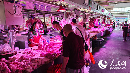 市场上正在批发猪肉的商户人民网记者 李彤摄