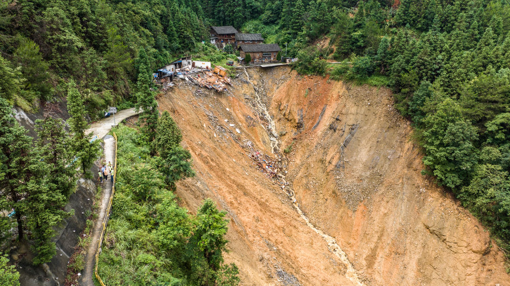 这是猴子河特大桥旁发生山体滑坡的三都县都江镇新合村民房(6月24日摄,无人机照片)。新华社记者 陶亮 摄