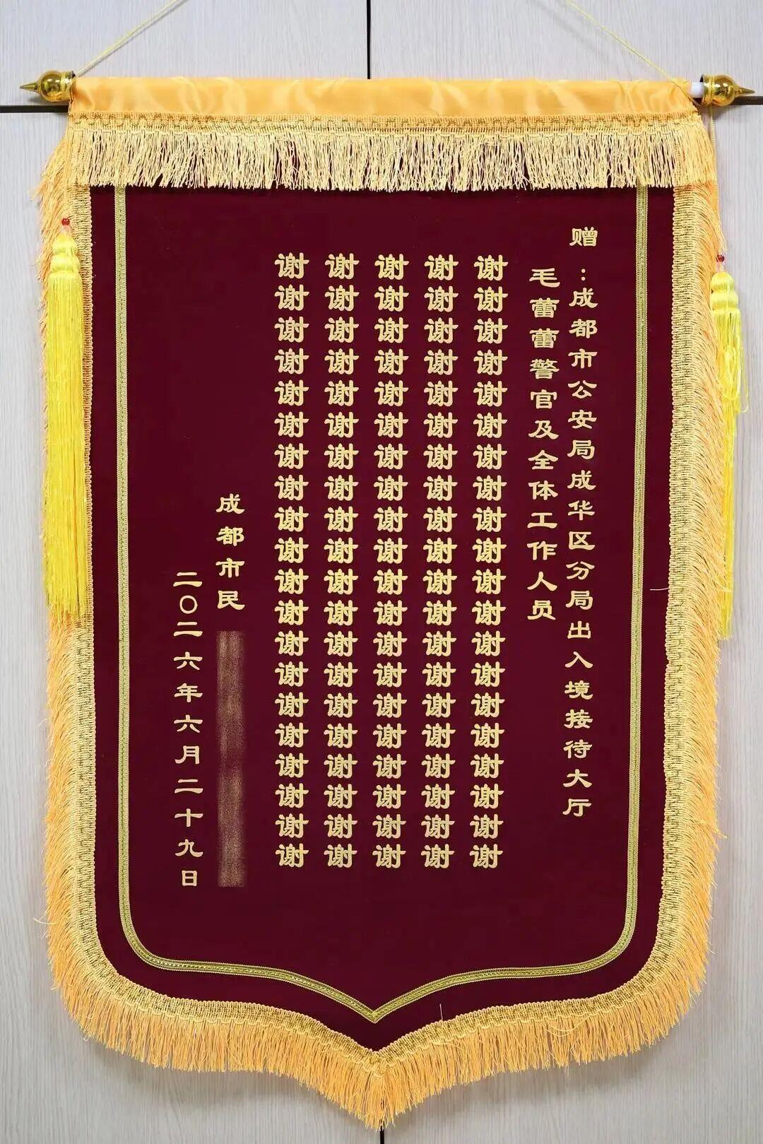 △一位男士将一面写有一百个“谢”字的锦旗送到成都成华公安出入境接待大厅。