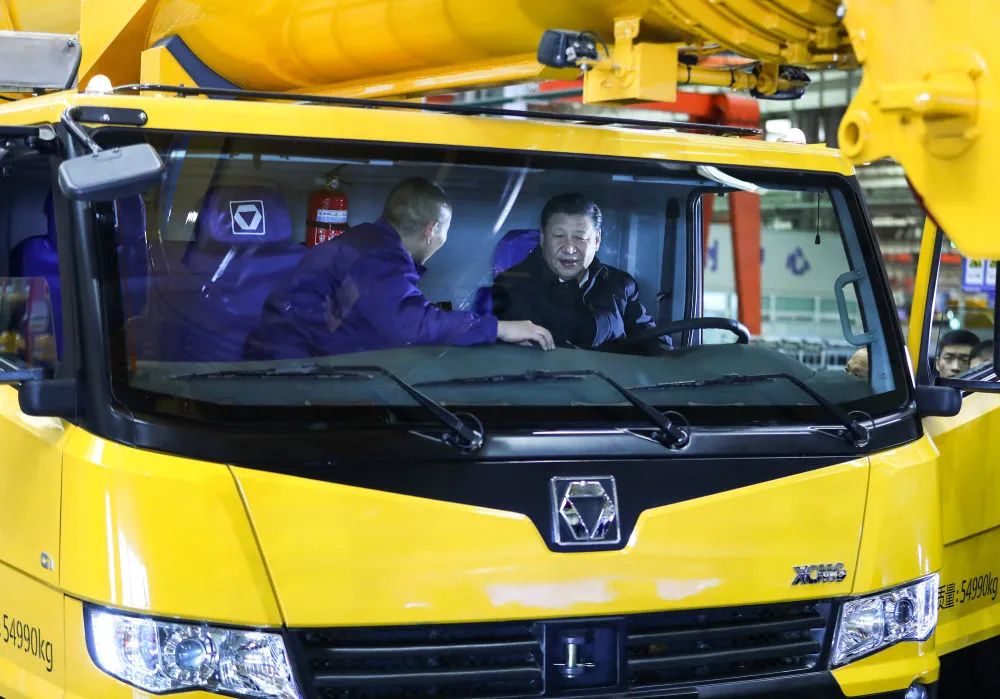 2017年12月12日,习近平在江苏徐州徐工集团坐进刚下线的XCA220型全地面起重机驾驶室,向技术人员详细询问起重机的性能、产量、价格等。(图源:新华社)