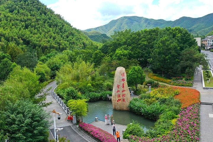 2025年8月6日,在浙江省湖州市安吉县余村,游客在刻有“绿水青山就是金山银山”的石碑前留影(无人机照片)。新华社记者 毛竹 摄