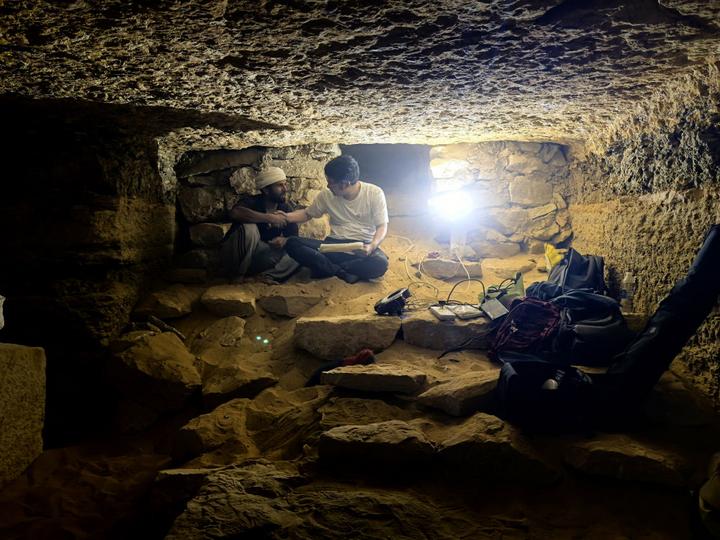 9月16日,在埃及开罗以南的萨卡拉考古遗址区,中埃萨卡拉联合考古项目中方领队薛江(右)和埃方同行在一座贵族墓内工作。(受访者供图)