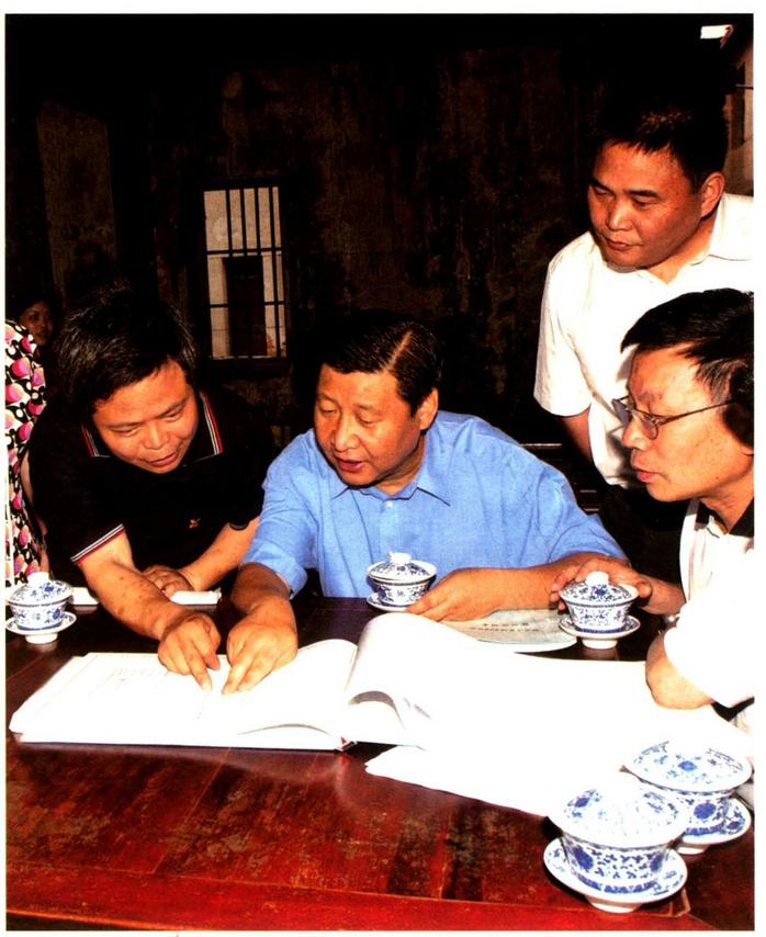 2006年6月,时任浙江省委书记的习近平在金华市磐安县玉山镇考察古茶场,查看建设图纸。