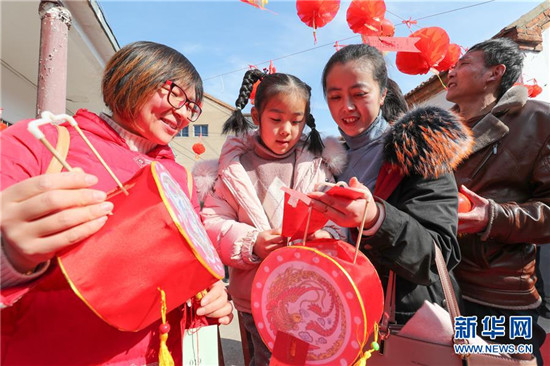 2月16日,在江苏省连云港市赣榆区青口镇前进社区,居民参加猜灯谜活动.