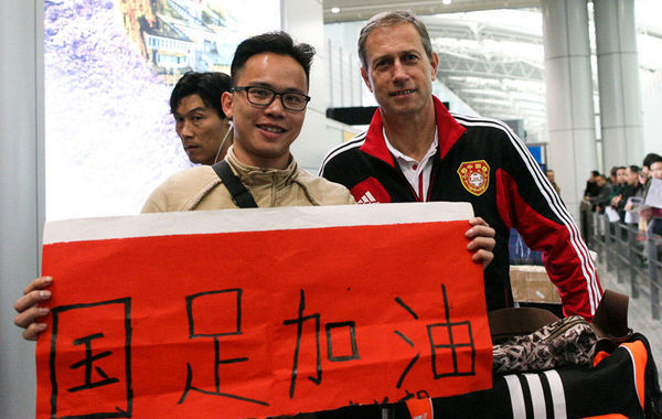 2014年3月6日，广州，国足头顶“被出线”光环回国，球迷竖大拇指。