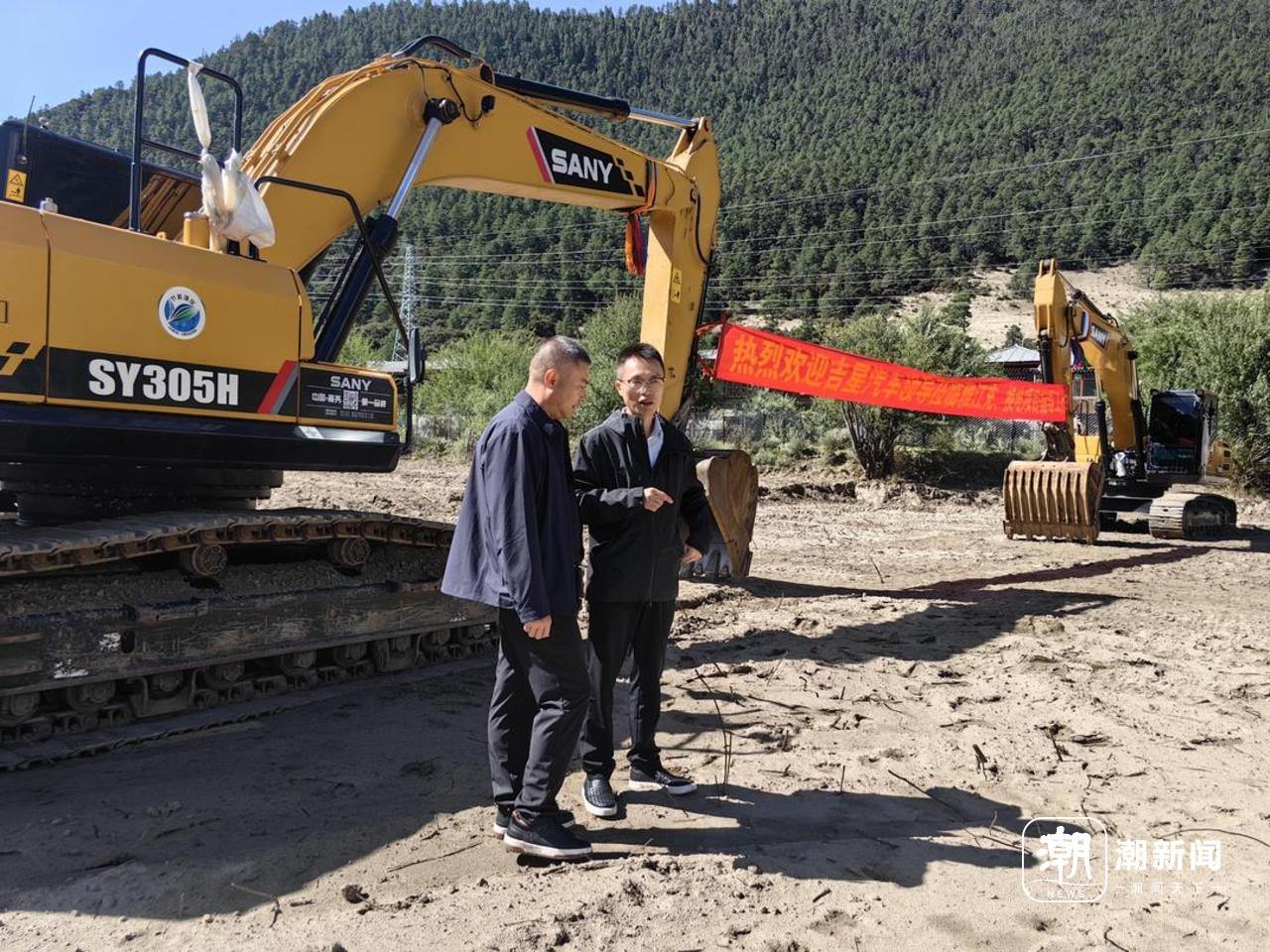 林育(右)在林芝雅江新能源重卡充换电站工地。甘居鹏 摄